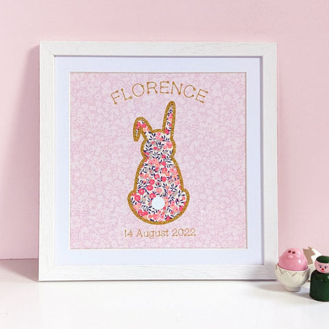 A print for a newborn baby showing a rabbit made from Liberty fabric edged with gold glitter featuring name and date of birth